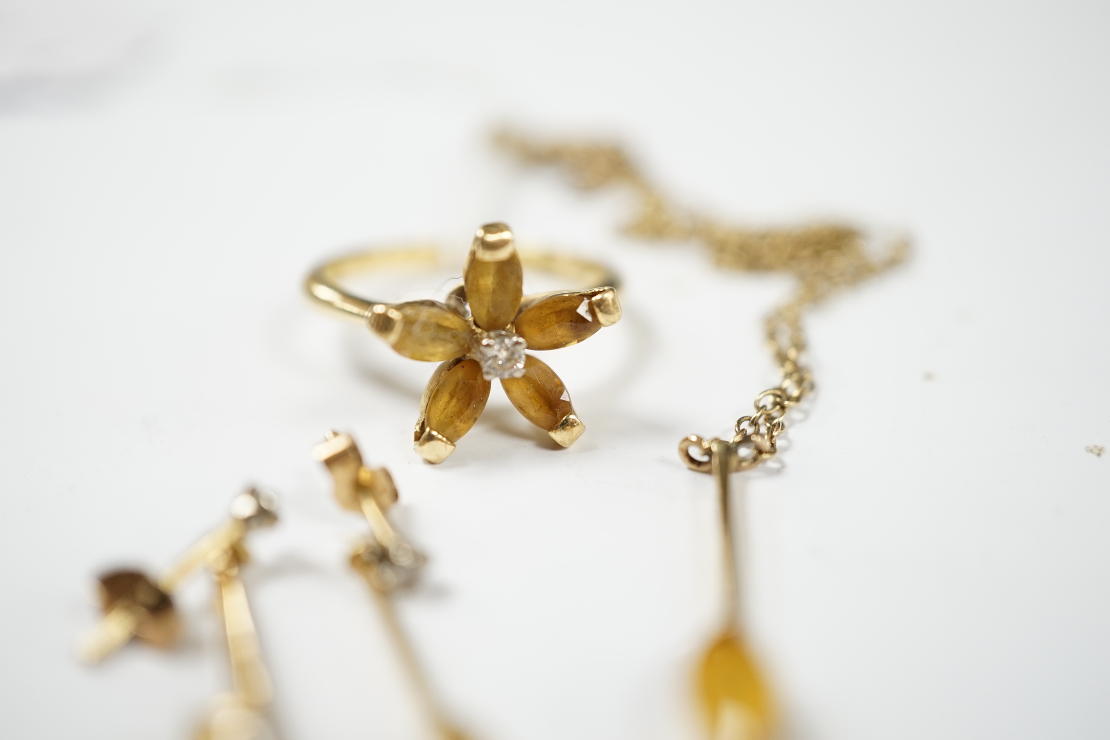 A yellow metal, citrine and diamond set suite of jewellery, comprising a ring (stamped 18ct), size O, pair of earrings, and a pendant of a 9ct chain. Condition - fair